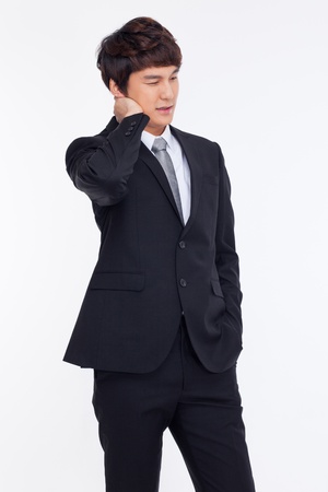 A tired Asian business man isolated on white background.の写真素材
