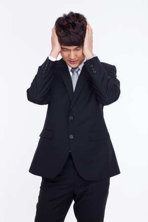 A tired Asian business man isolated on white background.の写真素材