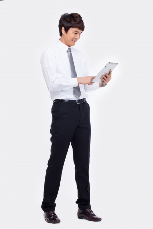 Young Asian business man using a pad PC isolated on white の写真素材