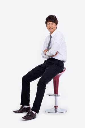 Young Asian business man sitting on the chair isolated on white background. の写真素材