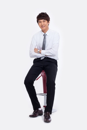 Young Asian business man sitting on the chair isolated on white background. の写真素材