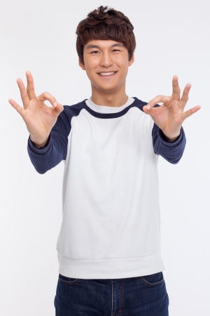 Young asian man showing okay sign isolated on white background. の写真素材