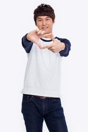 Young Asian man showing frame shape isolated on white background.の写真素材