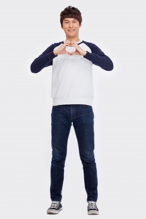 Young Asian man showing heart shape isolated on white background. の写真素材