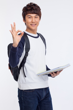 Young Asian stdudent showing okay sign isolated on white background. の写真素材