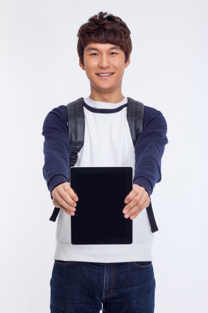 Young Asian student using pad PC isolated on white background. の写真素材