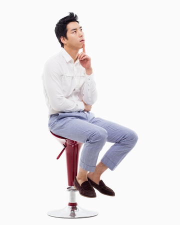 Young Asian man thinking on the chair isolated on white backgroung. の写真素材