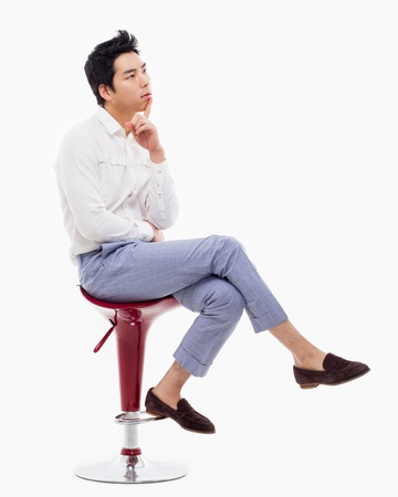Young Asian man thinking on the chair isolated on white backgroung. の写真素材
