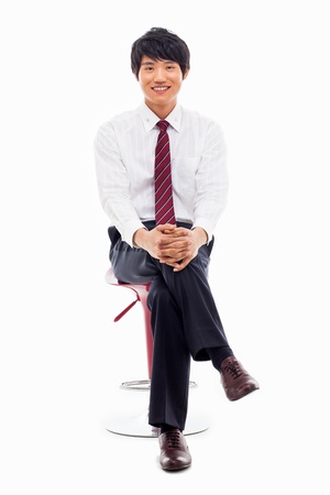 Young Asian business man sitting on the chair isolated on white background. の写真素材