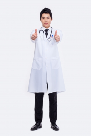 Young Asian doctor showing thumb isolated on white background.の写真素材