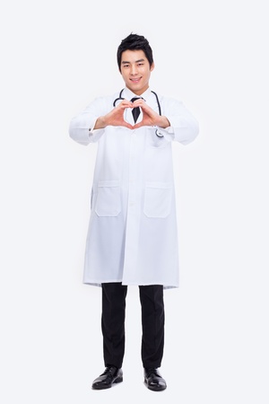 Young Asian doctor shwoing heart shape isolated on white background.の写真素材
