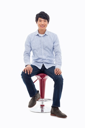Young Asian person sitting on the chair isolated on white.の写真素材