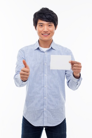 Young asian man showing empty card and showing thumb isolated on white background. の写真素材