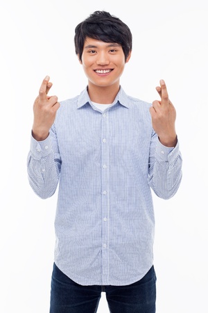Young asian man showing lucky sign isolated on white background. の写真素材