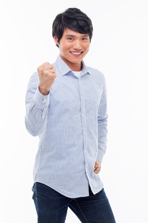 Young Asian man showing fist and happy sign isolated on white background. の写真素材