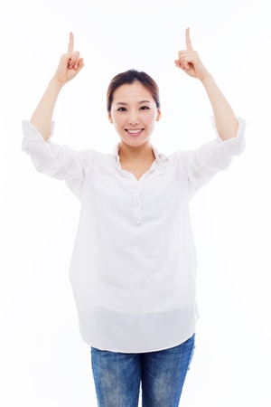 Smiling young woman pointing upwards isolated on white background. の写真素材