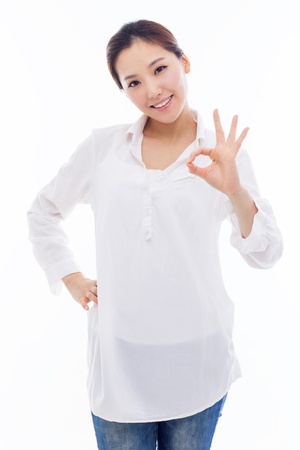 Cute woman with okay hand gesture isolated on white background. の写真素材