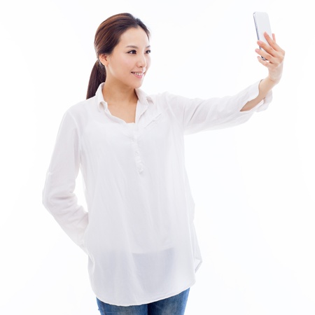 Young Asian woman using a smart phone isolated on white background. の写真素材