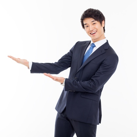 Young Asian business man showing something isolated on white background. の写真素材
