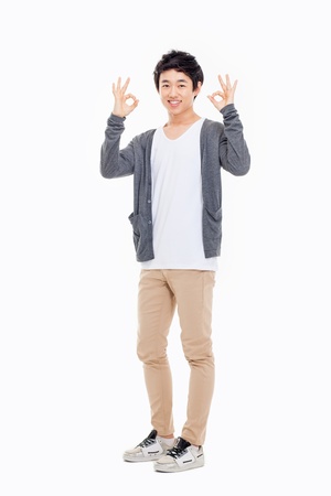 Young asian man showing okay sign isolated on white background. の写真素材
