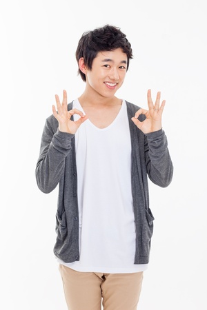 Young asian man showing okay sign isolated on white background. の写真素材