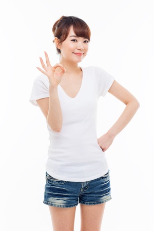 Cute woman with okay hand gesture isolated on white background. の写真素材