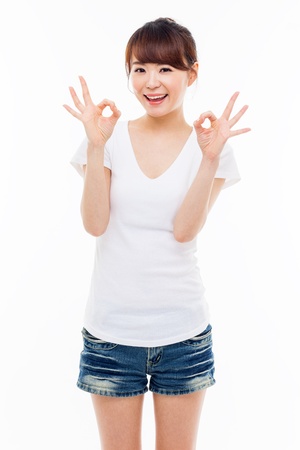 Cute woman with okay hand gesture isolated on white background. の写真素材