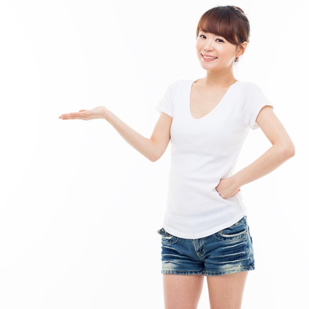 Young Asian woman showing something isolated on white background  の写真素材