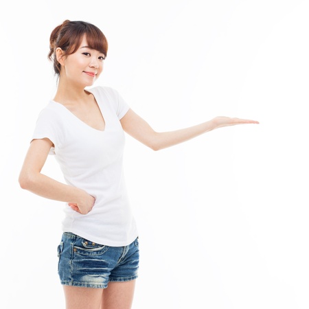 Young Asian woman showing something isolated on white background  の写真素材