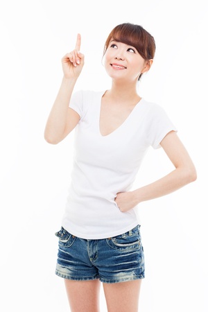 Smiling young woman pointing upwards isolated on white background  の写真素材
