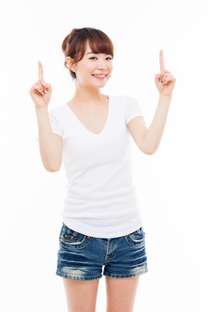 Smiling young woman pointing upwards isolated on white background  の写真素材