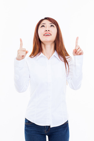 Smiling young woman pointing upwards の写真素材