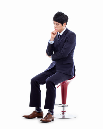 Thinking Young Asian business man sitting on the chair の写真素材