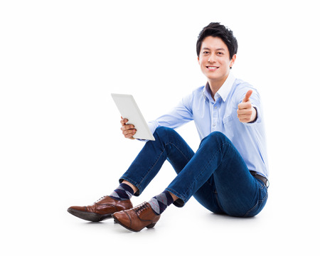 young Asian man having a smard pad PC isolated on white background. の写真素材