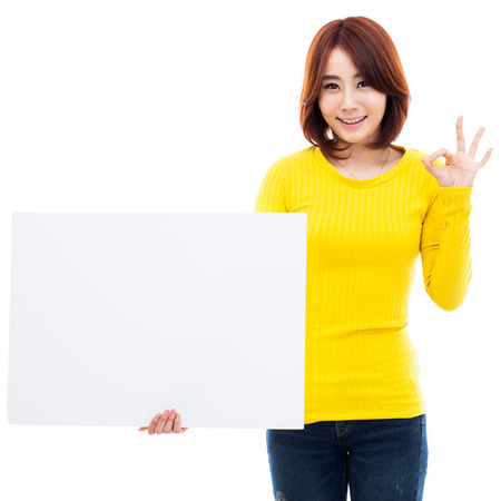 Young Asian woman holding a white borad isolated on white background.の写真素材