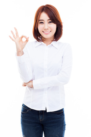 Cute woman with okay hand gesture isolated on white background. の写真素材