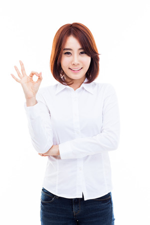 Cute woman with okay hand gesture isolated on white background. の写真素材
