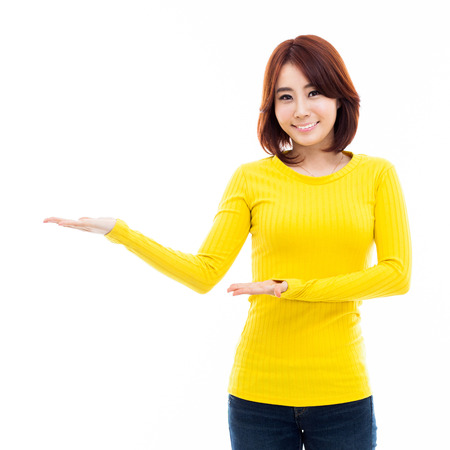 Young Asian woman showing something isolated on white の写真素材
