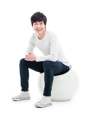 Young Asian person sitting on the chair isolated on white.の写真素材