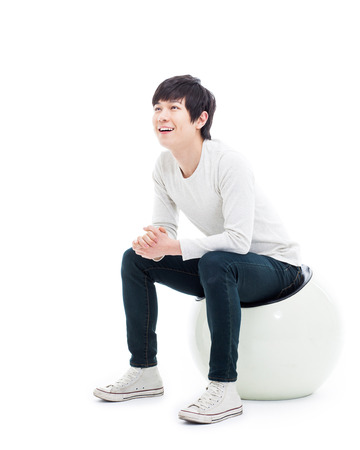 Young Asian man thinking on the chair isolated on white backgroung. の写真素材