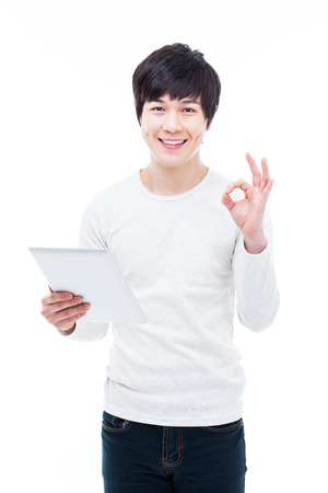 young Asian man having a smart pad PC isolated on white background. の写真素材