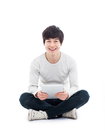 Young Asian man using a Pad PC isolated on white background. の写真素材