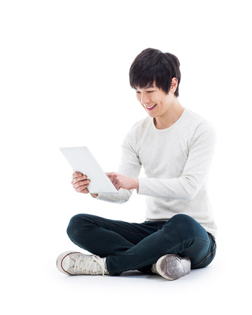 Young Asian man using a Pad PC isolated on white background. の写真素材