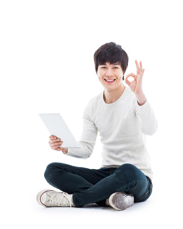 Young Asian man using a Pad PC isolated on white background. の写真素材