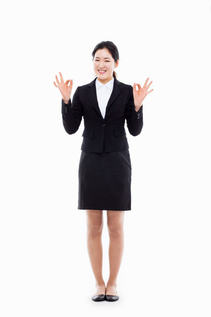 Successful happy Asian businesswoman showing okay sign isolated on white background. の写真素材