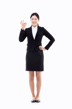 Successful happy Asian businesswoman showing okay sign isolated on white background. の写真素材