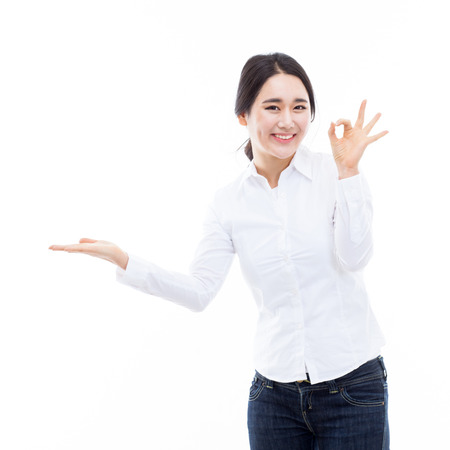 Young Asian woman showing something isolated on white background  の写真素材