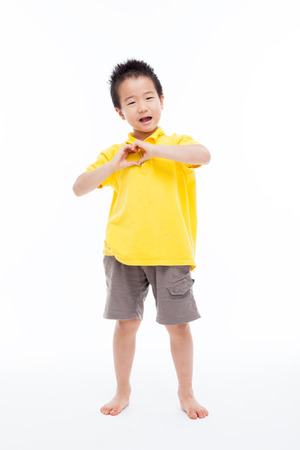 Young Asian boy showing heart shape isolated on white.の写真素材