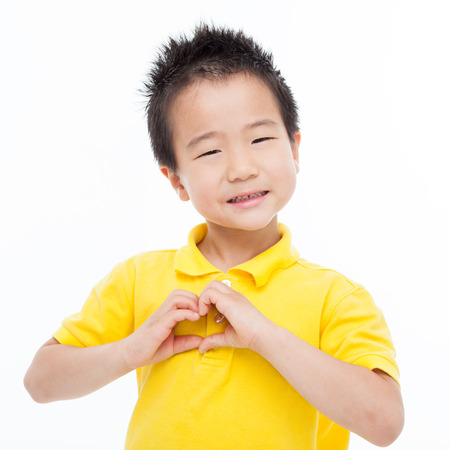 Young Asian boy showing heart shape isolated on white.の写真素材