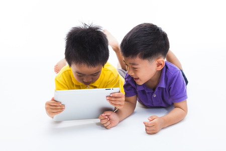 Asian boys using tablet PC isolated on white.の写真素材
